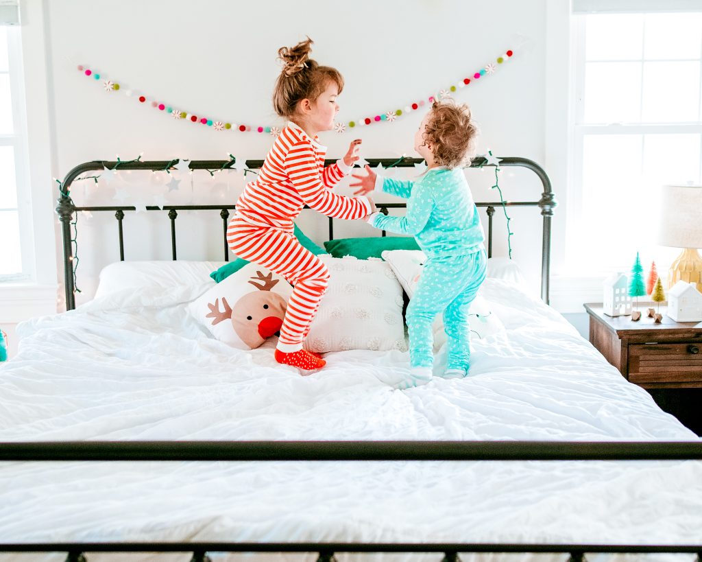 Brother and Sister jumping on festive bed!