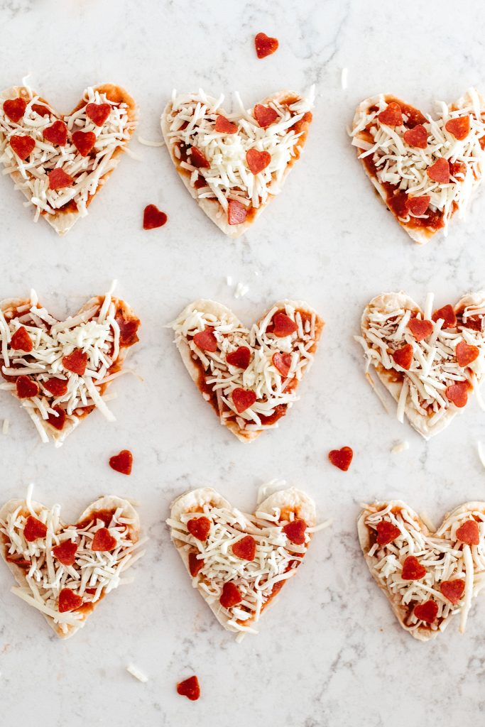 Looking for Valentine family dinner ideas? Here's a simple recipe for mini heart pizza to make with your kids! 