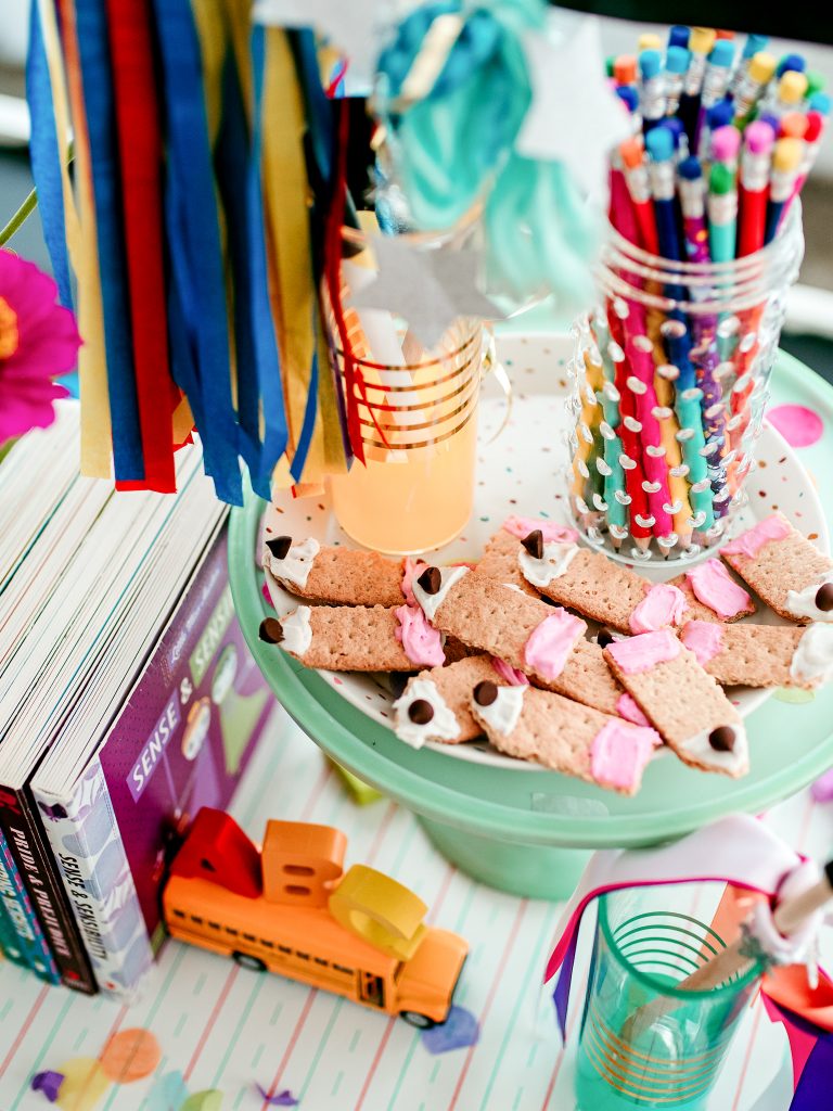 A cute and simple school treat; trimmed graham crackers decorated with cream cheese and a chocolate chip pencil tip. 