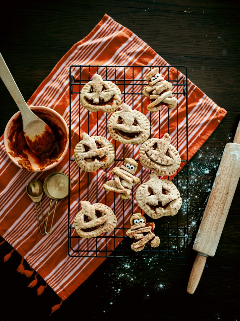 Homemade halloween snack ideas including these adorable pumpkin hand-pies in the shape of mummies and jack-o-lanterns