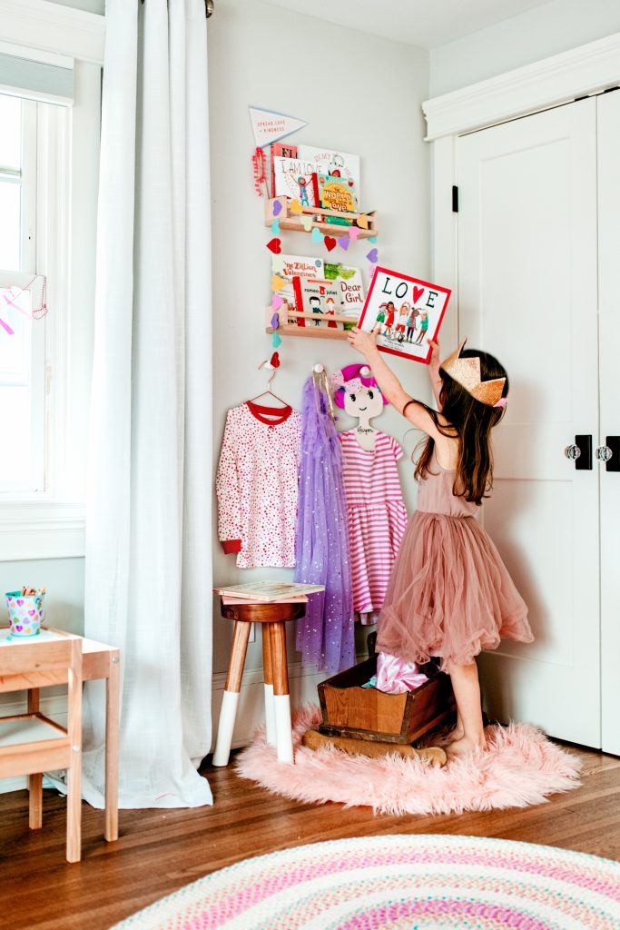 A whimsical book corner for a little girl's room filled with Valentine's Day books for kids