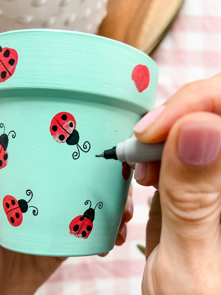 Make an adorable fingerprint art lady bug flower pot. Easy steps to make a fingerprint spring craft with kids 