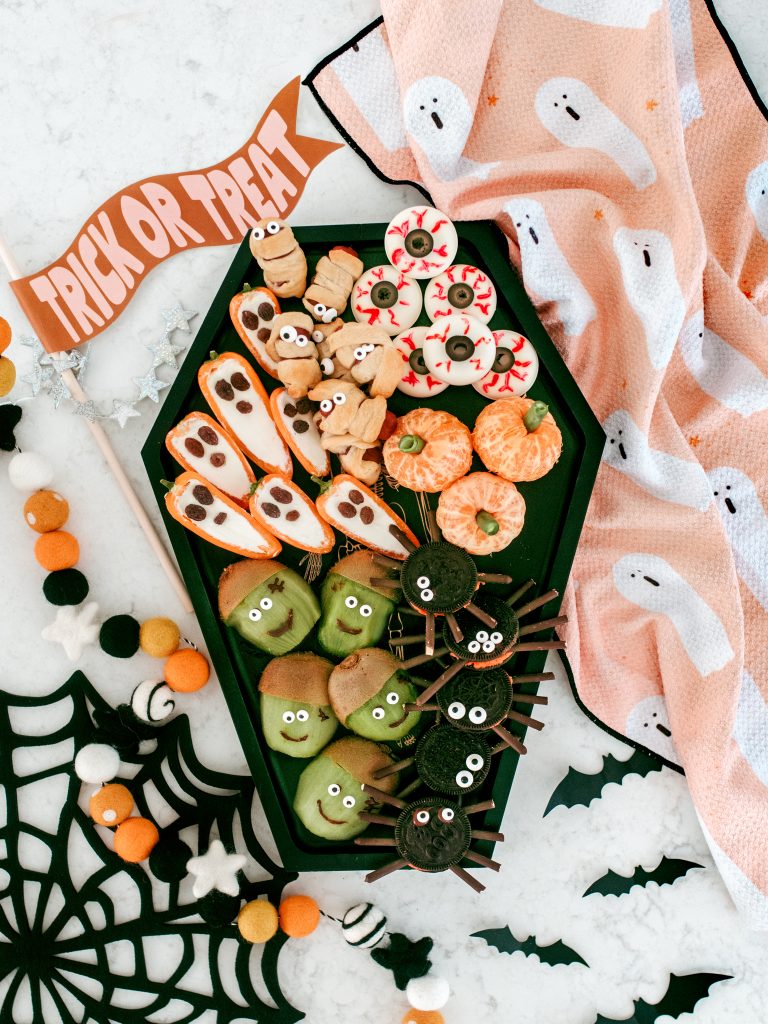 Halloween snack board with homemade spooky snacks. Healthy Halloween treats. 